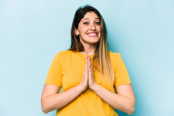 Jonge Blanke Vrouw Geïsoleerd Blauwe Achtergrond Hand Hand Bidden Buurt — Stockfoto