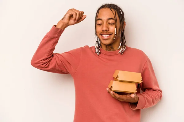 Jovem Afro Americano Segurando Hambúrguer Isolado Fundo Branco Levantando Punho — Fotografia de Stock