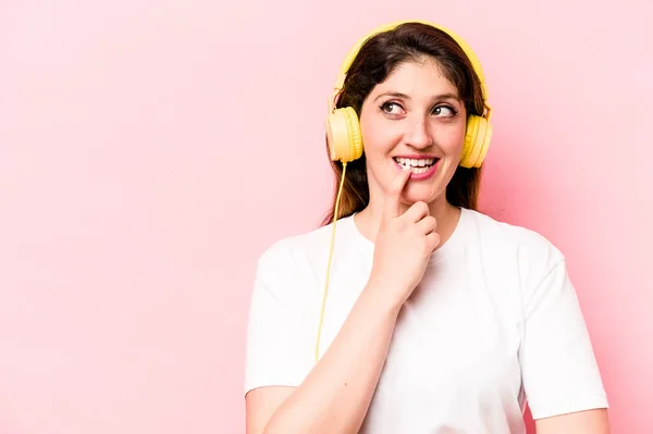 Young Caucasian Woman Listening Music Isolated Pink Background Relaxed Thinking — Φωτογραφία Αρχείου