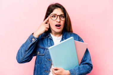 Pembe arka planda izole edilmiş genç beyaz kadın işaret parmağıyla hayal kırıklığı jesti gösteriyor..