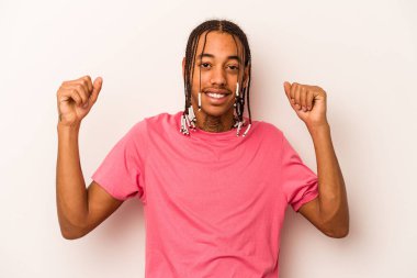 Genç Afrikalı Amerikalı adam beyaz arka planda izole edilmiş tasasız ve heyecanlı bir şekilde tezahürat yapıyor. Zafer konsepti.