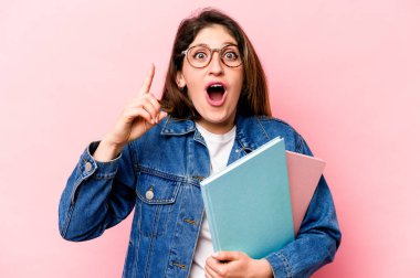 Pembe arka planda izole edilmiş genç beyaz bir kadının bir fikri var, ilham verici bir kavram..