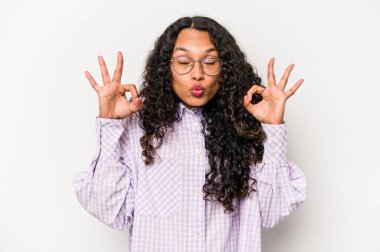 Beyaz arka planda izole edilmiş genç İspanyol kadın sıkı çalışma gününden sonra rahatlıyor, yoga yapıyor..