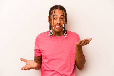 Beyaz arka planda izole edilmiş genç Afrikalı Amerikalı adam kollarıyla ölçek oluşturuyor, mutlu ve kendinden emin hissediyor..