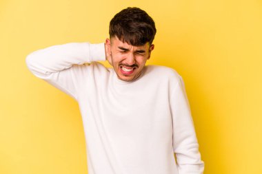 Sarı arka planda izole edilmiş genç beyaz adam sabit yaşam tarzından dolayı boyun ağrısından muzdarip..