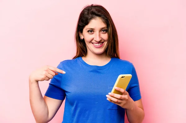 Mladá Běloška Drží Mobilní Telefon Izolovaný Růžovém Pozadí Osoba Ukazuje — Stock fotografie