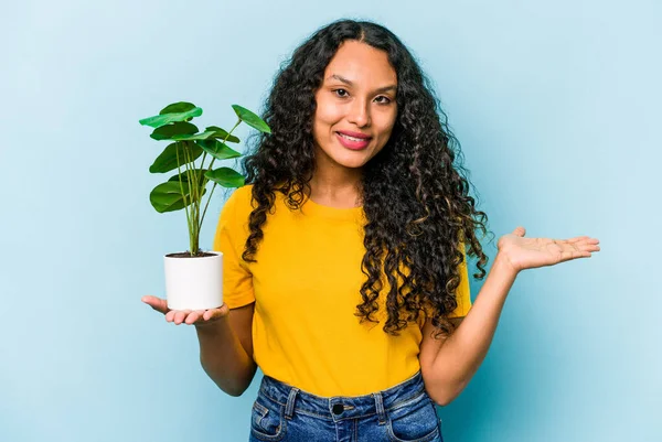 Ung Latinamerikansk Kvinna Håller Växt Isolerad Blå Bakgrund Visar Kopia — Stockfoto