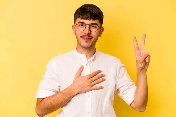 Νεαρός Καυκάσιος Απομονωμένος Κίτρινο Φόντο Δίνει Όρκο Βάζοντας Χέρι Στο — Φωτογραφία Αρχείου