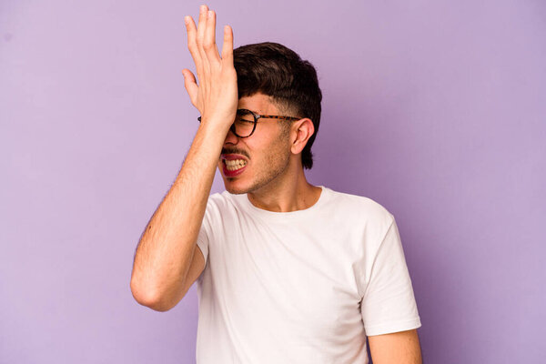 Young caucasian man isolated on purple background forgetting something, slapping forehead with palm and closing eyes.