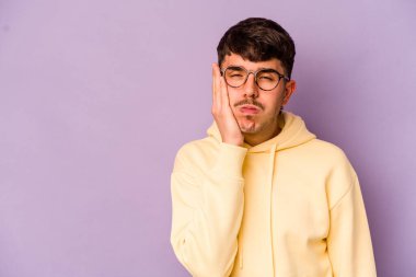 Mor arka planda izole edilmiş genç beyaz adam üzgün ve dalgın hissediyor, kopyalama alanına bakıyor..