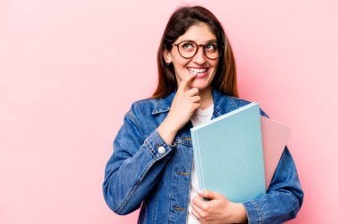 Pembe arka planda izole edilmiş genç beyaz kadın rahatça fotokopi odasına bakan bir şey düşünüyor..