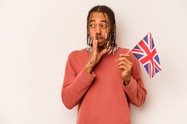 Beyaz arka planda izole edilmiş İngiliz bayrağı tutan genç Afro-Amerikan bir adam gizli bir sıcak fren haberi veriyor ve yana bakıyor.