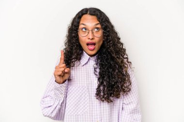 Beyaz arka planda izole edilmiş genç İspanyol kadın iki parmağı da boş bir alan gösteriyor..