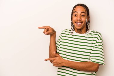 Beyaz arka planda izole edilmiş genç Afro-Amerikalı adam işaret parmağıyla işaret ettiği için heyecanlı..