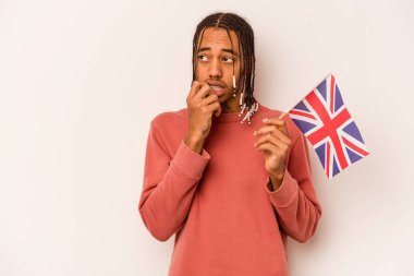 Beyaz arka planda izole edilmiş İngiliz bayrağı tutan genç Afrikalı Amerikalı bir adam. Bir şeyin fotokopi alanına baktığını düşünerek rahatlamış..
