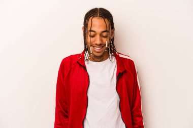 Beyaz arka planda izole edilmiş genç Afrikalı Amerikalı adam gülüyor ve gözlerini kapıyor, rahatlamış ve mutlu hissediyor..