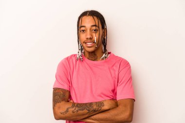 Beyaz arka planda izole edilmiş genç bir Afrikalı Amerikalı. Kendine güveniyor, kararlılıkla kollarını kavuşturuyor..