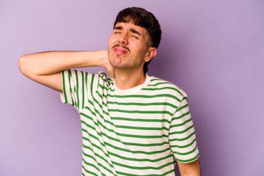 Genç beyaz adam mor arka planda izole edilmiş dirsek masajı yapıyor, kötü bir hareketin ardından acı çekiyor..