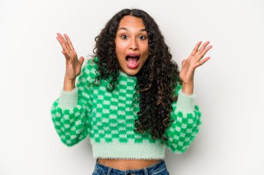 Latin kökenli genç bir kadın zaferi ya da başarıyı kutlarken beyaz arka planda mahsur kaldı. Şaşırdı ve şok oldu..