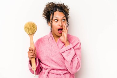 Beyaz arka planda izole edilmiş sırt kaşıyıcı tutan genç İspanyol kadın gizli bir sıcak fren haberi veriyor ve yan bakıyor.