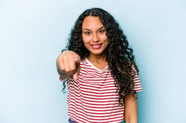 Mavi arka planda izole edilmiş genç İspanyol kadın. Önü işaret eden neşeli gülümsemeler..