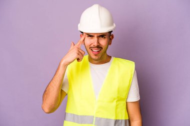 Mor arka planda izole edilmiş genç bir İspanyol işçi işaret parmağıyla bir hayal kırıklığı gösteriyor..