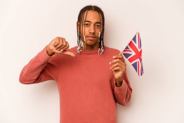 Beyaz arka planda izole edilmiş İngiliz bayrağı tutan genç Afro-Amerikan bir adam hoşlanmadığı bir jest gösteriyor. Anlaşmazlık konsepti.