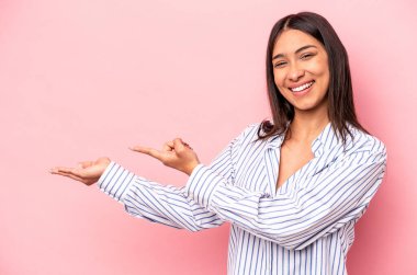 Pembe arka planda izole edilmiş genç İspanyol bir kadın. Elinde bir fotokopi odası olduğu için heyecanlı..