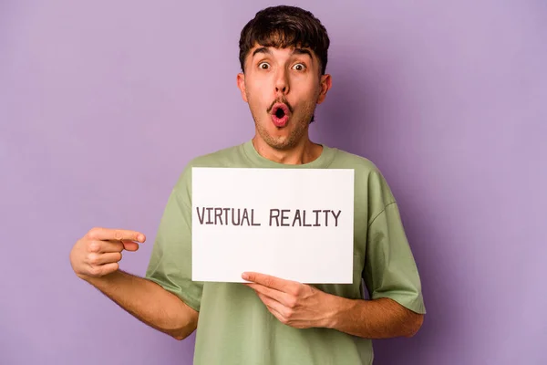Jovem Hispânico Segurando Cartaz Realidade Virtual Isolado Fundo Roxo Apontando — Fotografia de Stock