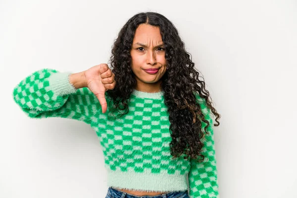 Beyaz arka planda izole edilmiş genç İspanyol kadın baş parmağını aşağı gösteriyor, hayal kırıklığı konsepti.