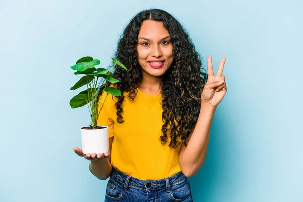 Ung Latinamerikansk Kvinna Håller Växt Isolerad Blå Bakgrund Visar Nummer — Stockfoto