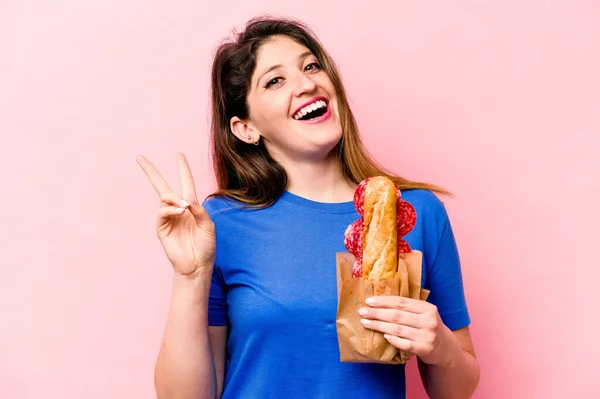 Junge Kaukasische Frau Isst Ein Sandwich Isoliert Auf Rosa Hintergrund — Stockfoto
