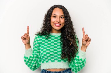 Beyaz arka planda izole edilmiş genç İspanyol kadın iki parmağı da boş bir alan gösteriyor..