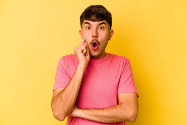 Sarı arka planda izole edilmiş genç beyaz bir adam harika bir fikri, yaratıcılık kavramı var..