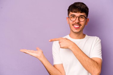 Mor arka planda izole edilmiş genç beyaz bir adam, elinde bir fotokopi alanı tutarken heyecanlanıyor..