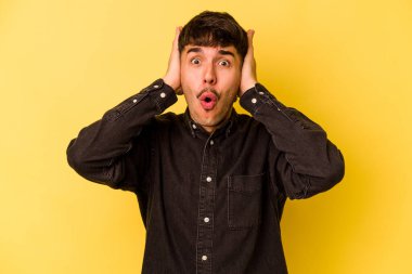 Sarı arka planda izole genç beyaz adam şok oldu, o önemli bir toplantı hatırladı.