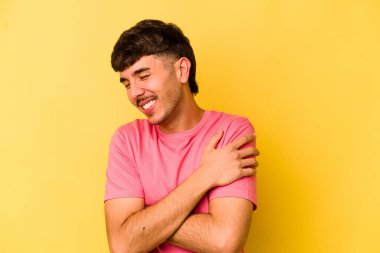 Sarı arka planda izole genç beyaz adam gülüyor ve eğleniyor..