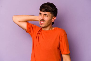 Mor arka planda izole edilmiş genç beyaz adam yorgun ve uykulu ellerini başının üstünde tutuyor..