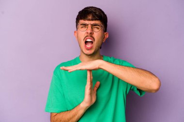 Mor arka planda izole edilmiş genç beyaz bir adam bir mola hareketi gösteriyor..