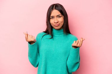 Pembe arka planda izole edilmiş genç İspanyol kadın parasız olduğunu gösteriyor..