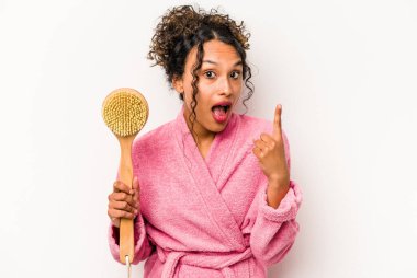 Beyaz arka planda izole edilmiş sırt kaşıyıcısı tutan genç İspanyol kadının bir fikri var, ilham verici bir kavram..