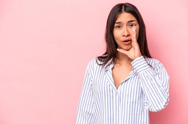 Pembe arka planda izole edilmiş genç İspanyol kadın gizli bir sıcak fren haberi veriyor ve yan bakıyor.