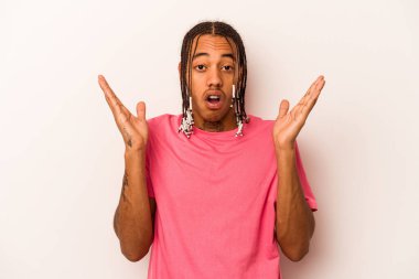 Genç Afrikalı Amerikalı adam beyaz arka planda izole edilmiş, şaşırmış ve şok olmuş..