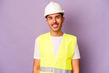Genç İspanyol işçi mor arka planda izole edilmiş mutlu, güler yüzlü ve neşeli.