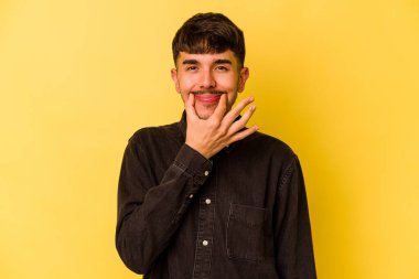 Kafkasyalı genç, sarı arka planda izole edilmiş, iki seçenek arasında şüphe duyuyor..