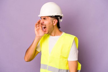Genç İspanyol işçi, mor arka planda izole edilmiş bağırıyor ve avuç içini açık tutuyor..