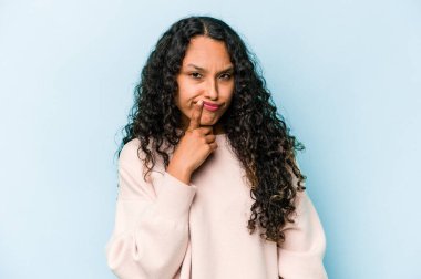 Genç İspanyol kadın mavi arka planda izole edilmiş düşünüyor, bakıyor, yansıtıyor, düşünüyor, hayal kuruyor..