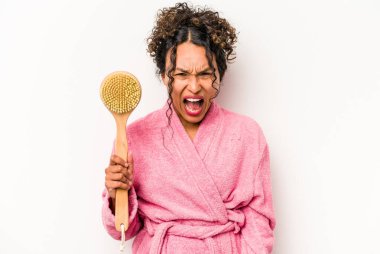 Beyaz arka planda izole edilmiş sırt kaşıyıcı tutan genç İspanyol kadın çok sinirli ve agresif çığlıklar atıyor..