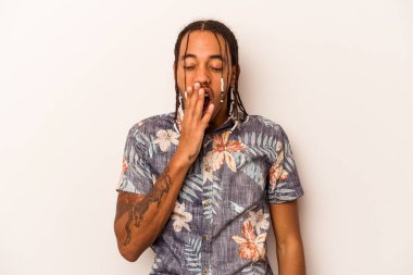 Beyaz arka planda izole edilmiş genç Afrikalı Amerikalı adam esniyor. Ağzını eliyle kapatan yorgun bir hareket sergiliyor..