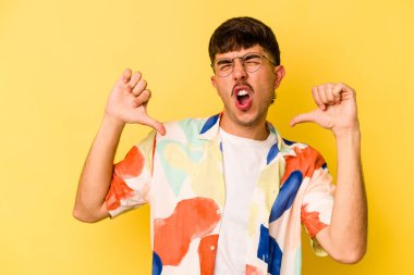 Sarı arka planda izole edilmiş genç beyaz adam gururlu ve kendinden emin hissediyor, örnek olarak.